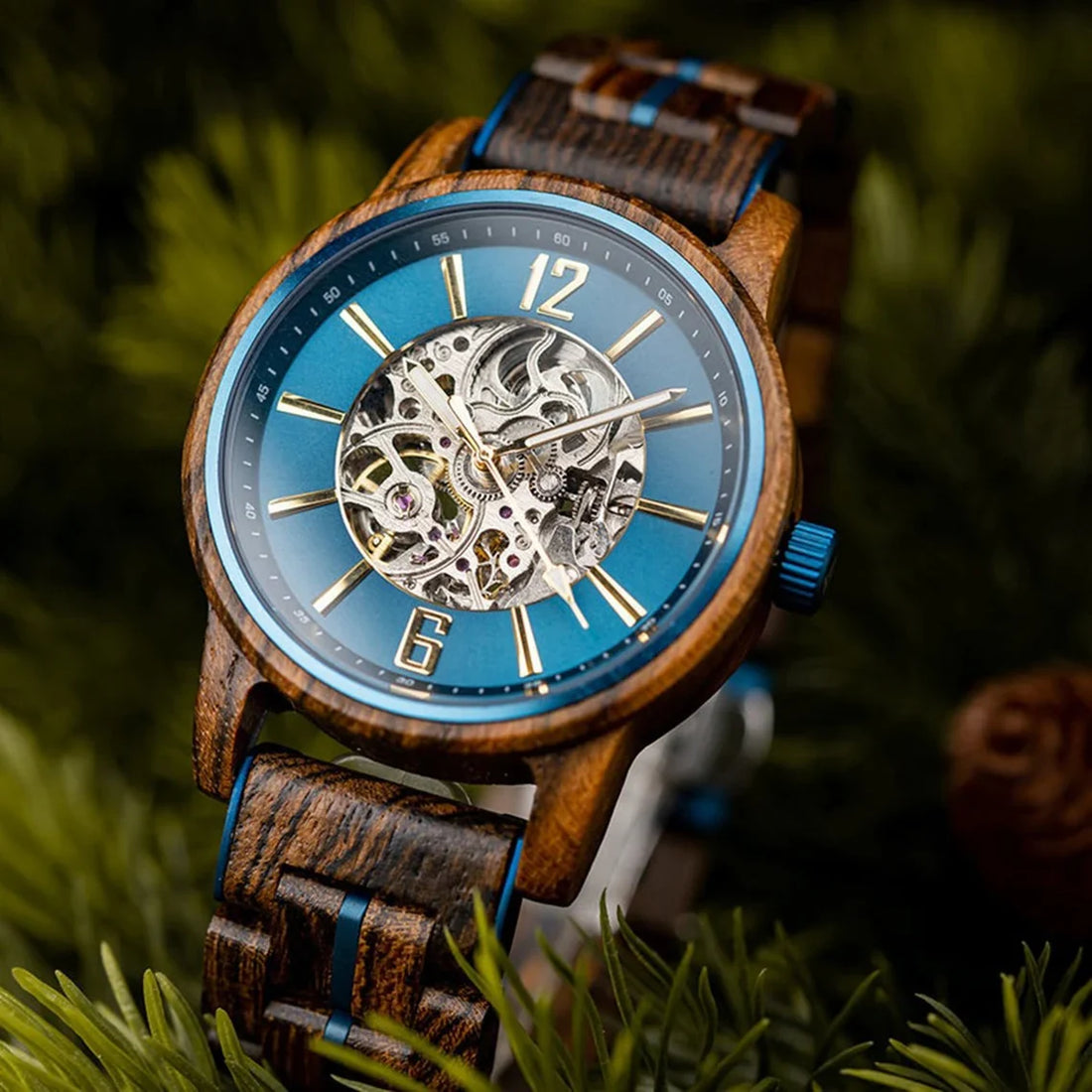 Riverstone wooden watch resting on fir branches, blue dial