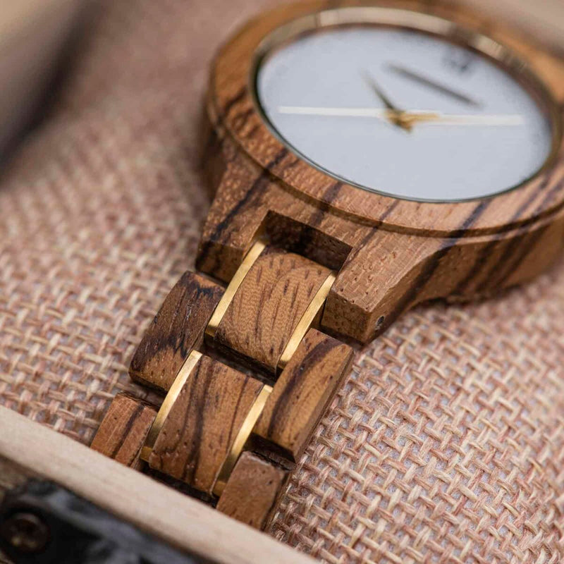 Close view of the Zara watch bracelet, zebrawood links with dark stripes and gold accents
