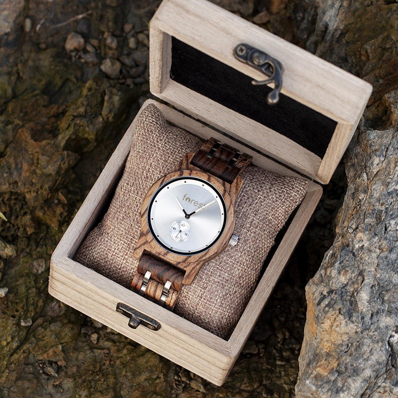 Alpine wooden watch in its wooden gift box, set on wet rock