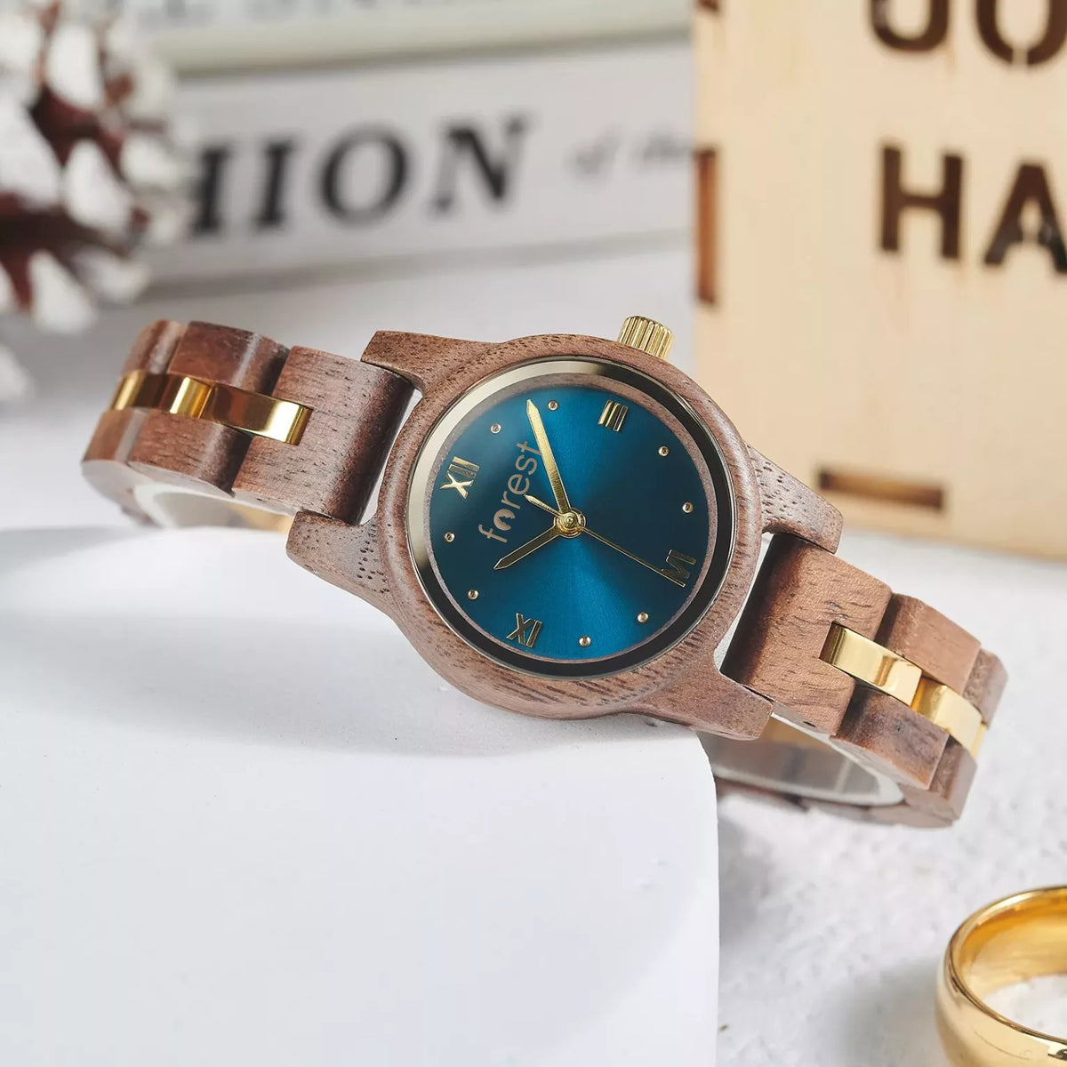 Blue dial Midnight wooden watch angled on a white block, walnut and gold link bracelet