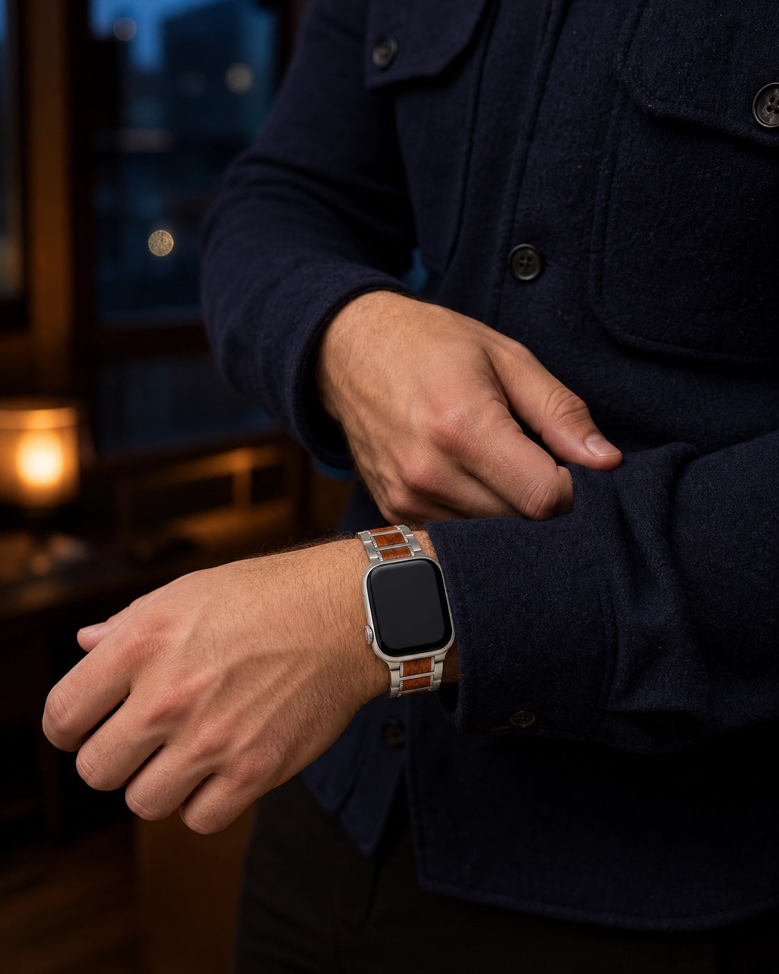 Wood and stainless-steel Apple Watch strap worn with a navy overshirt in the evening