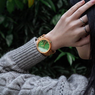 woman brushes her hair with her hand while wearing IVY forest wood watch