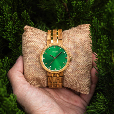 Forest watch made from olivewood on a pillow in a persons hand