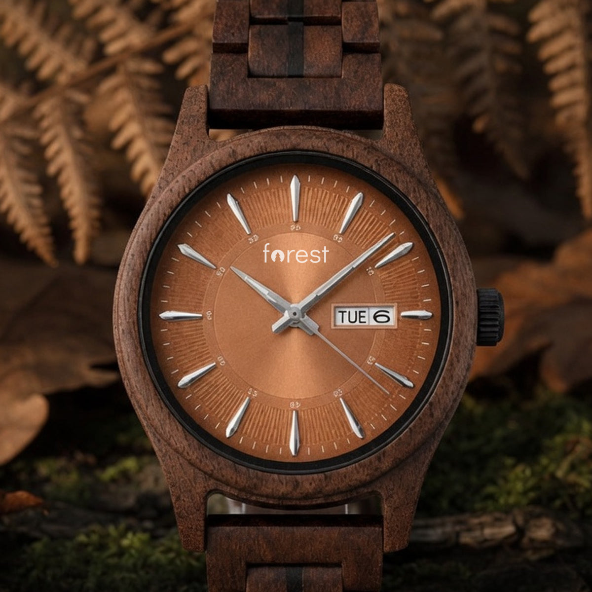Bracken walnut watch with copper dial, standing upright on an autumn woodland floor with bracken, front view
