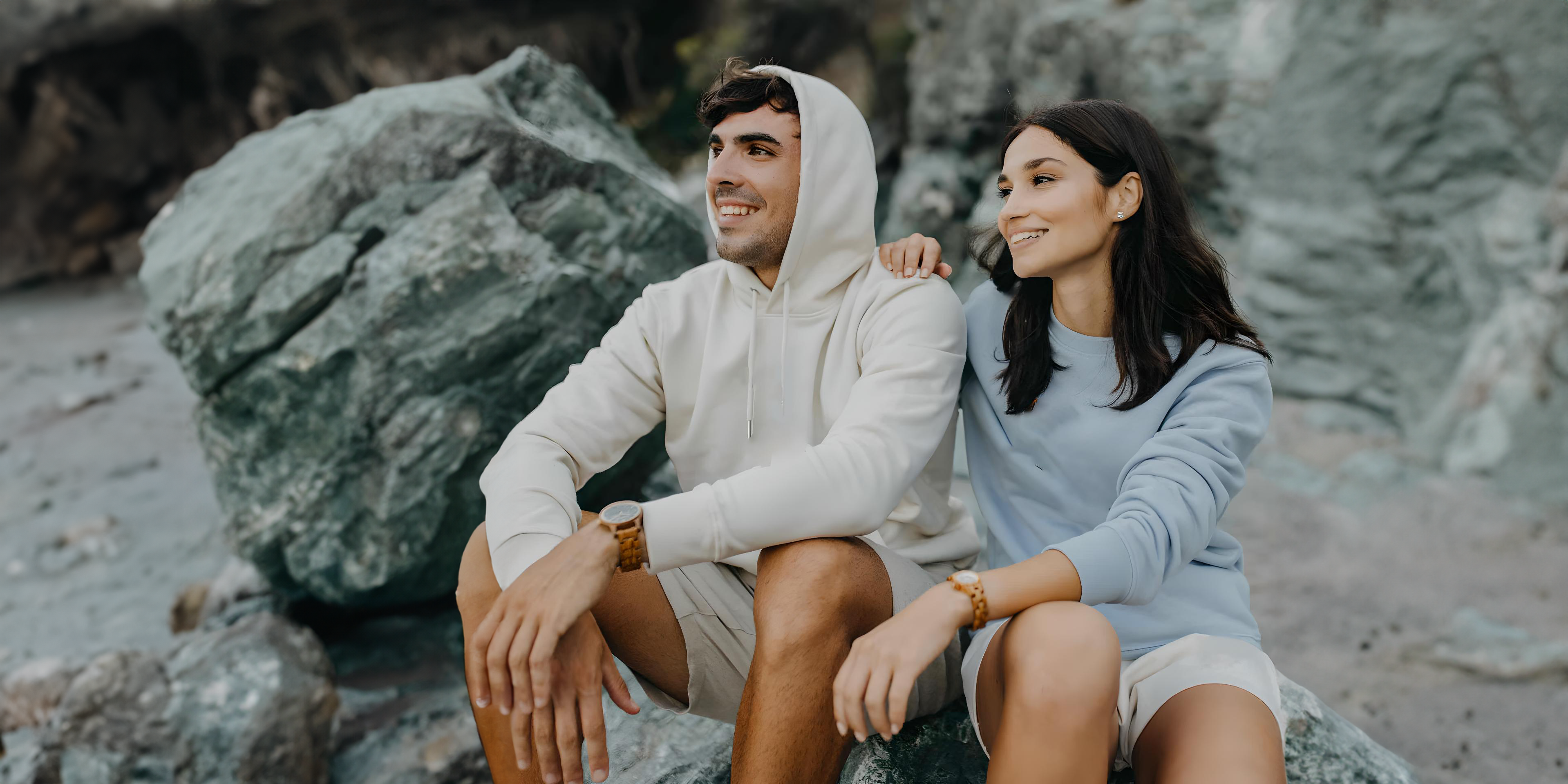 Couple sitting on rocks wearing Forest wooden watches