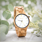 Dawn wooden watch low against pale wood, soft daylight behind