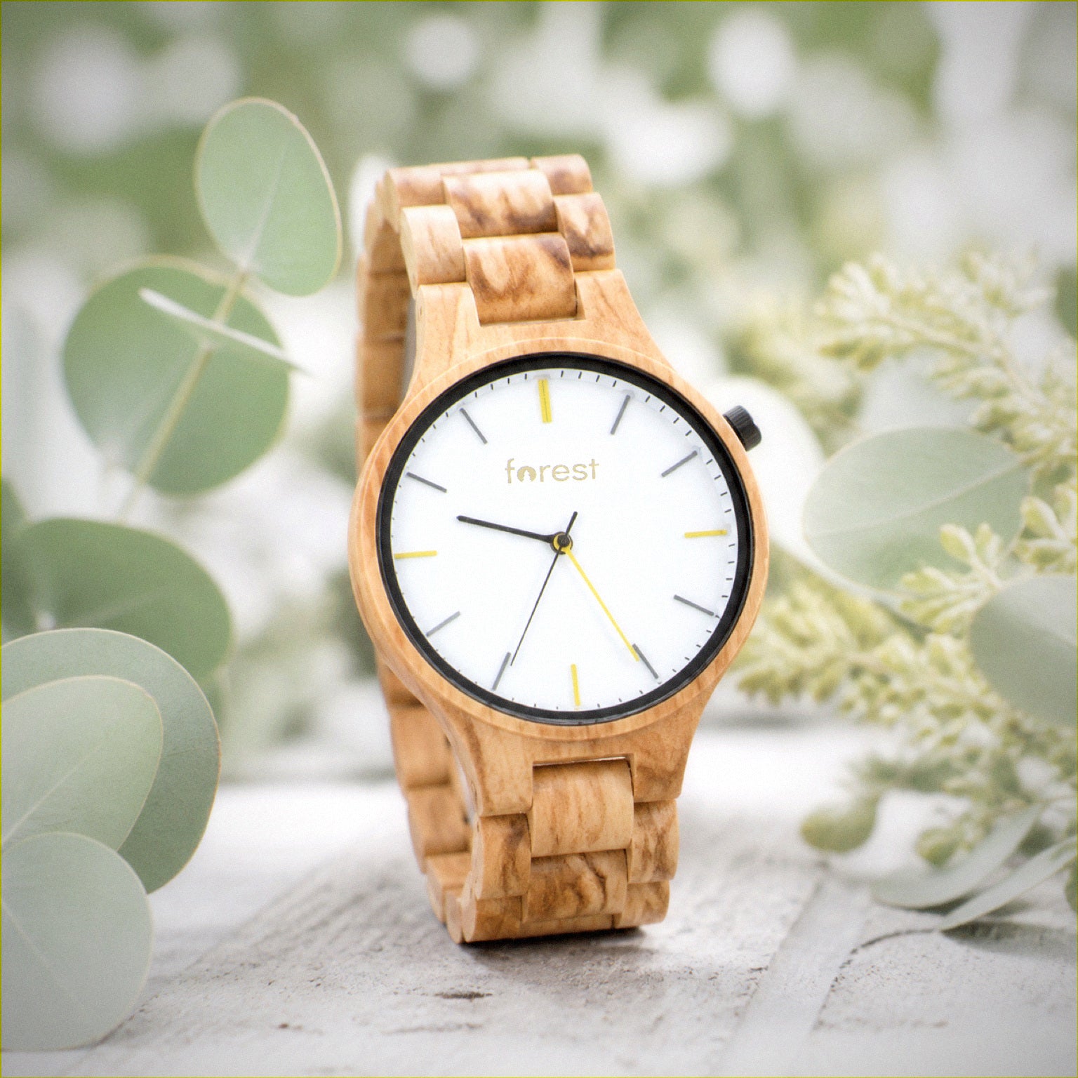 Dawn wooden watch low against pale wood, soft daylight behind