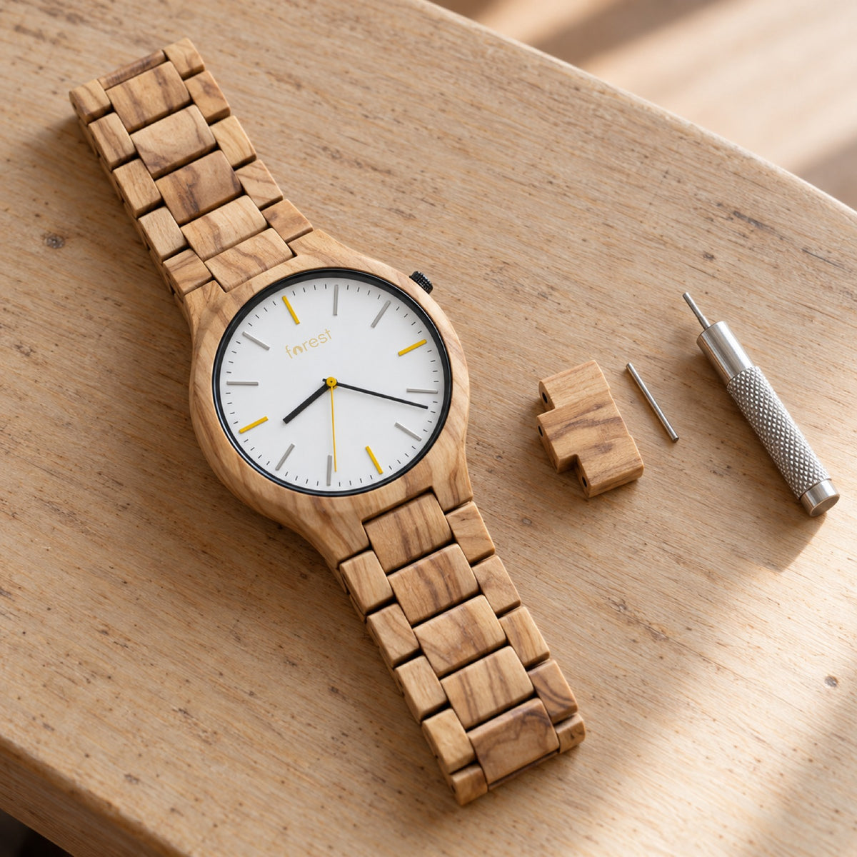 Dawn wooden watch with one link removed and the link tool beside it