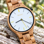 Dawn olivewood watch on pale driftwood, close-up of the white dial