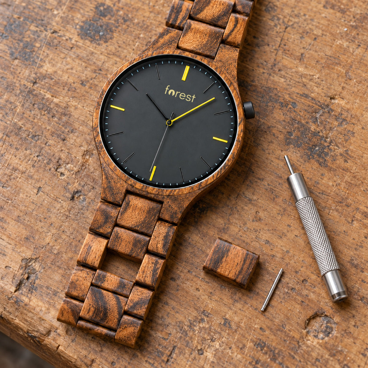 Dusk zebrawood watch with its middle link removed and the link tool beside it