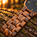 Close-up of Dusk's zebrawood bracelet links resting on a log