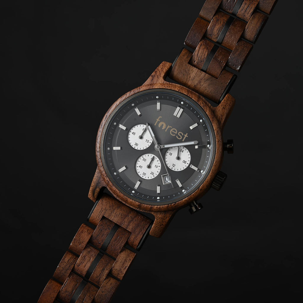 Woodland wooden watch angled on a black surface, walnut link bracelet