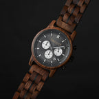 Woodland wooden watch angled on a black surface, walnut link bracelet