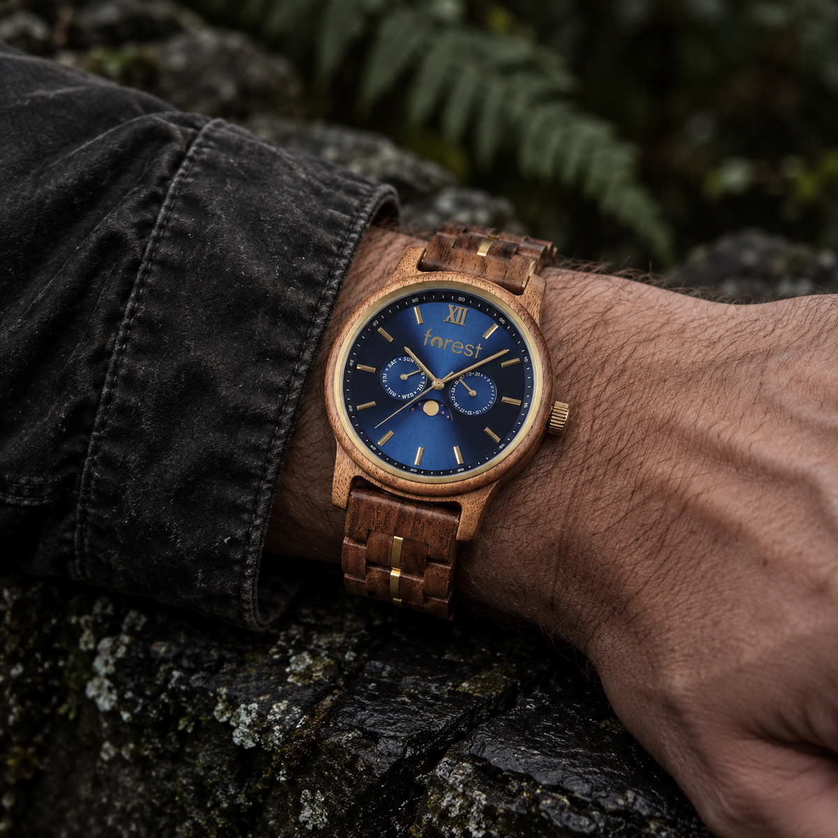 Windsor wooden watch worn on a wrist beside dark slate in shaded woodland