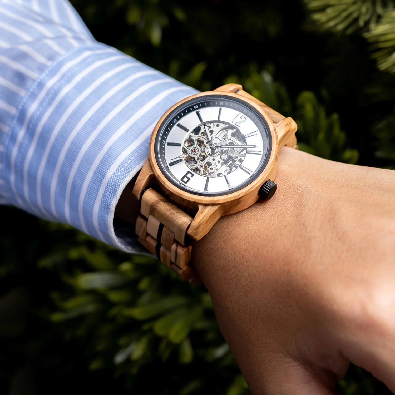 Black accent WOODHAVEN wooden watch worn on the wrist with a striped shirt, close view of the skeleton dial