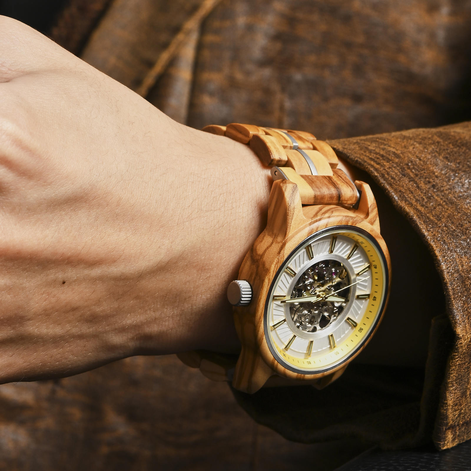 Gold/silver accent WOODHAVEN wooden watch worn on the wrist with a leather jacket