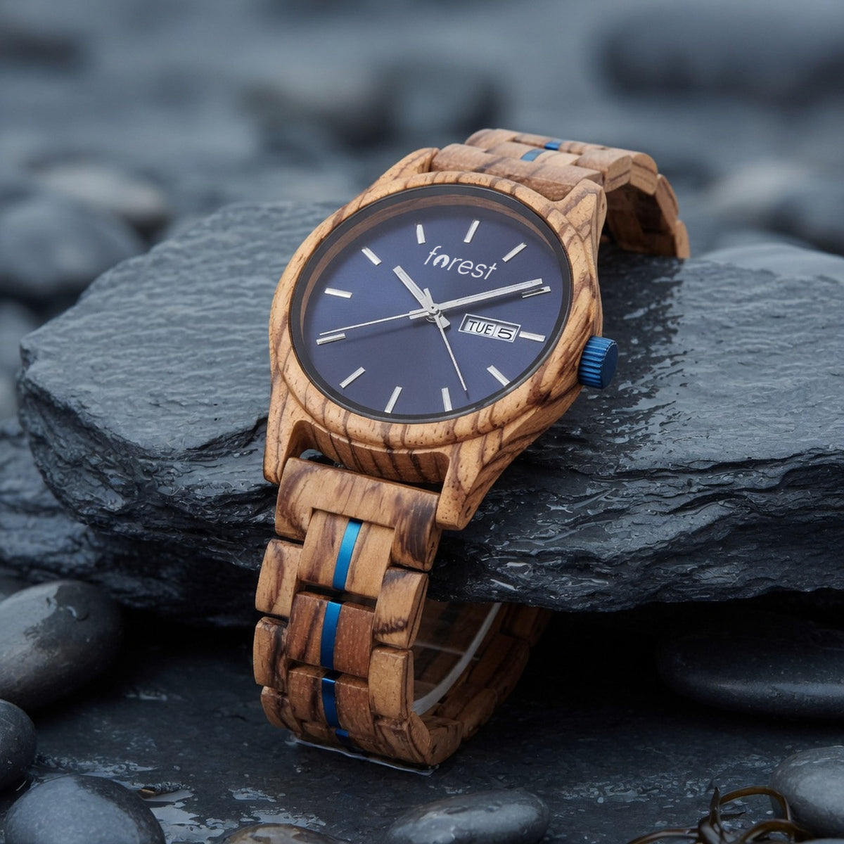 Harbour zebrawood watch with navy dial, draped over the edge of a slate slab, bracelet hanging
