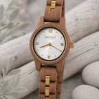 White dial Midnight wooden watch turned slightly, resting on pale driftwood