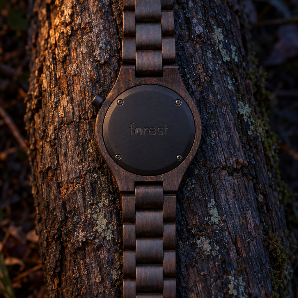 Nightfall watch lying face down, showing its black back engraved with forest