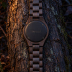 Nightfall watch lying face down, showing its black back engraved with forest