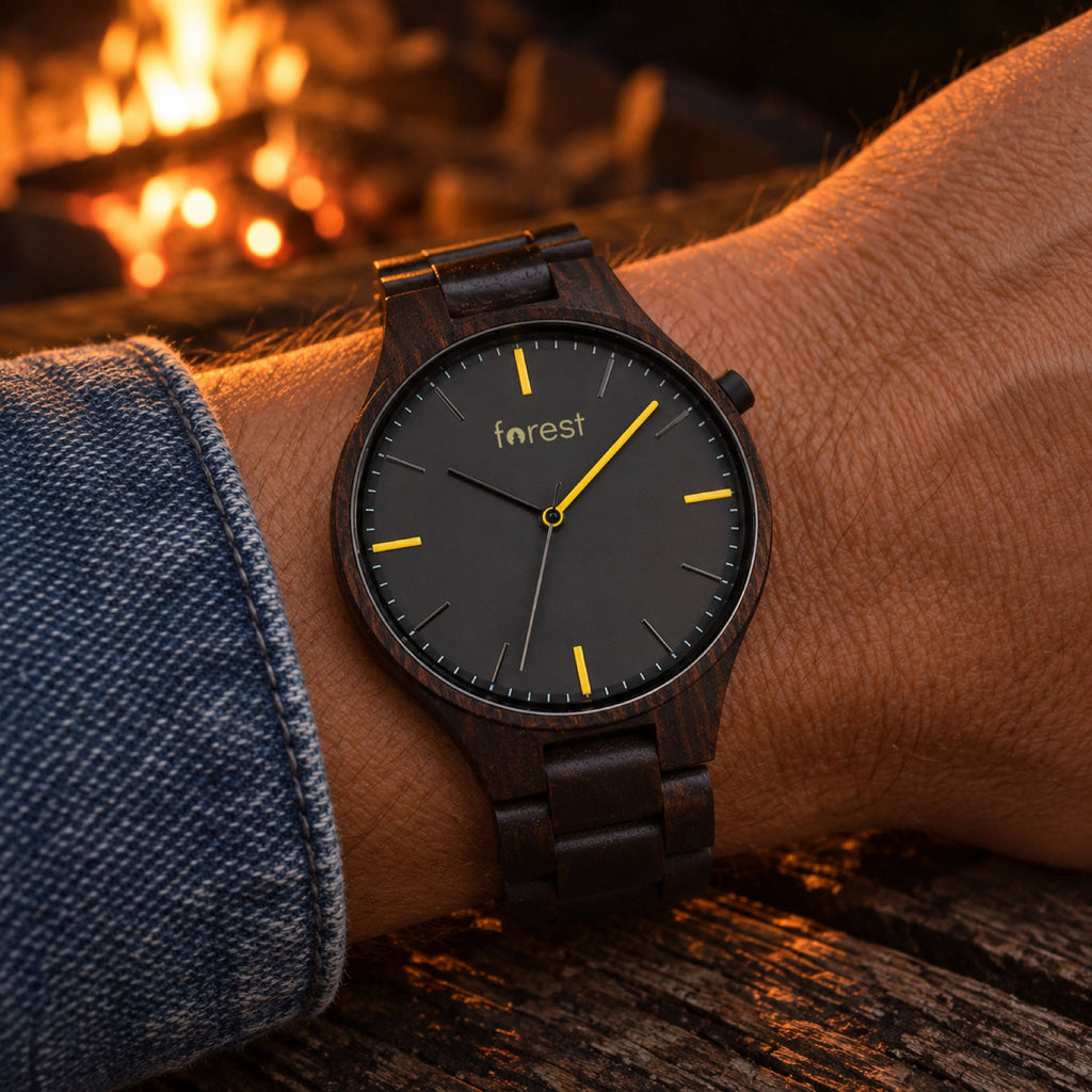 Nightfall ebony watch on a man's wrist by a campfire at night