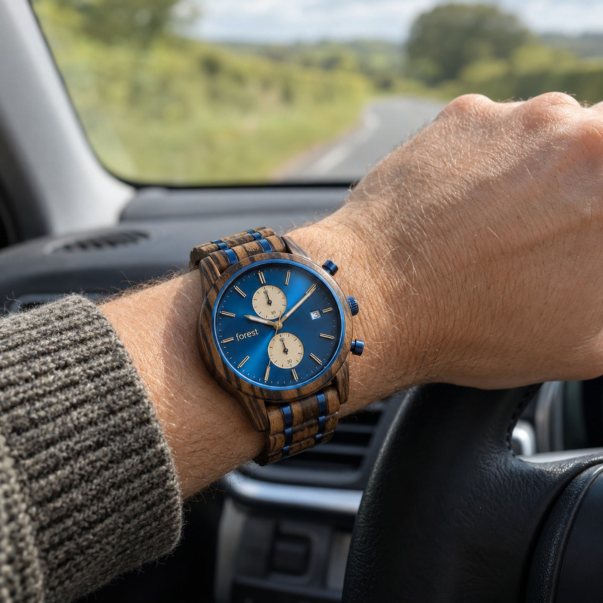 Nightjar wooden watch on a man's wrist, hand on a car steering wheel on a country road