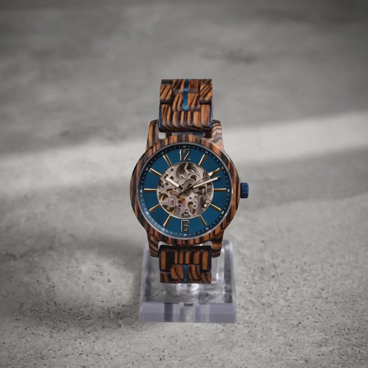 Riverstone wooden watch turning slowly on a studio stand, showing the dial, the case and the exhibition caseback