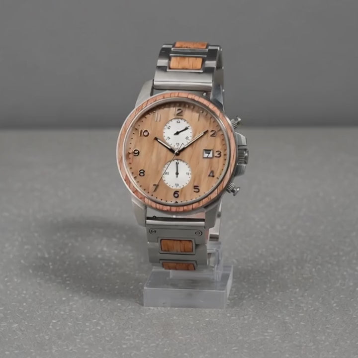 Barrel whiskey oak chronograph watch turning slowly on a studio stand, showing the dial, the case and the steel caseback