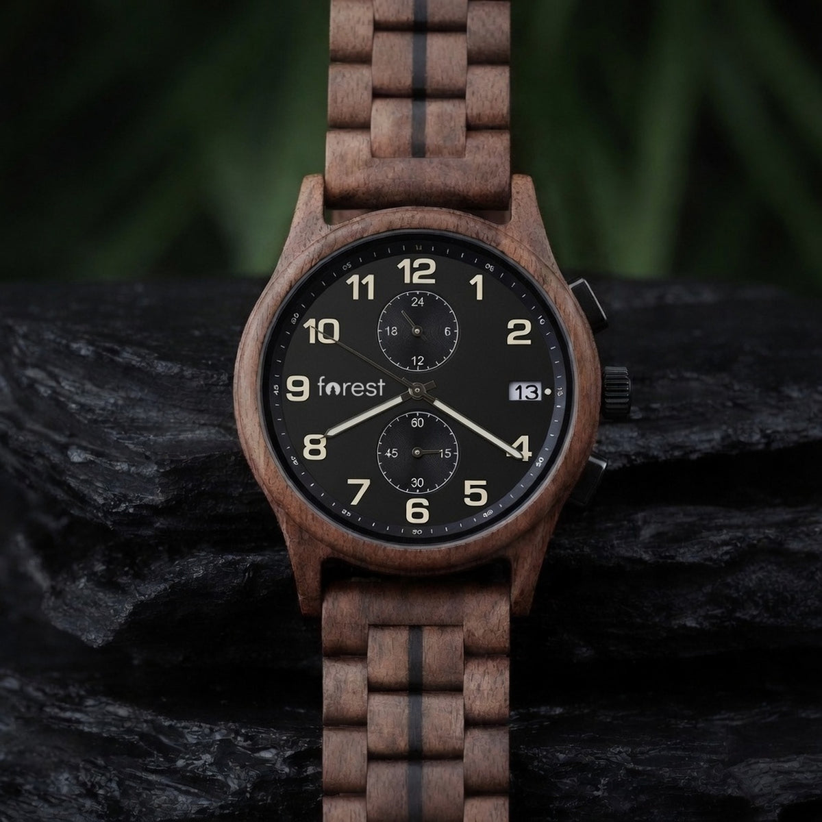 Raven walnut chronograph with black dial, standing upright on dark wet slate, front view