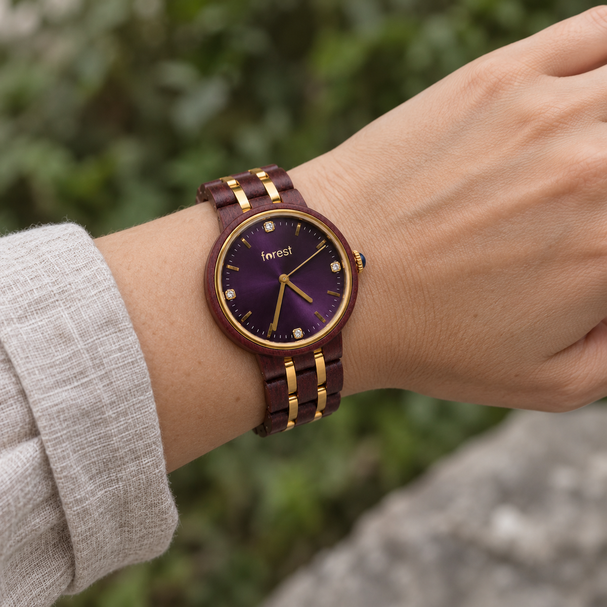 Royal rosewood and gold watch worn on a woman’s wrist beside an oatmeal linen sleeve