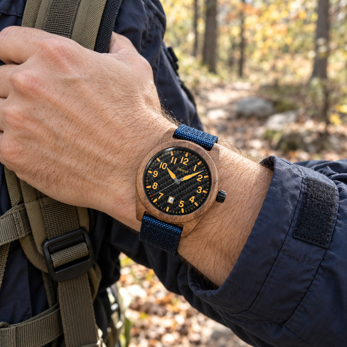 Scout wooden watch on a man's wrist, hand on a backpack strap on a woodland walk