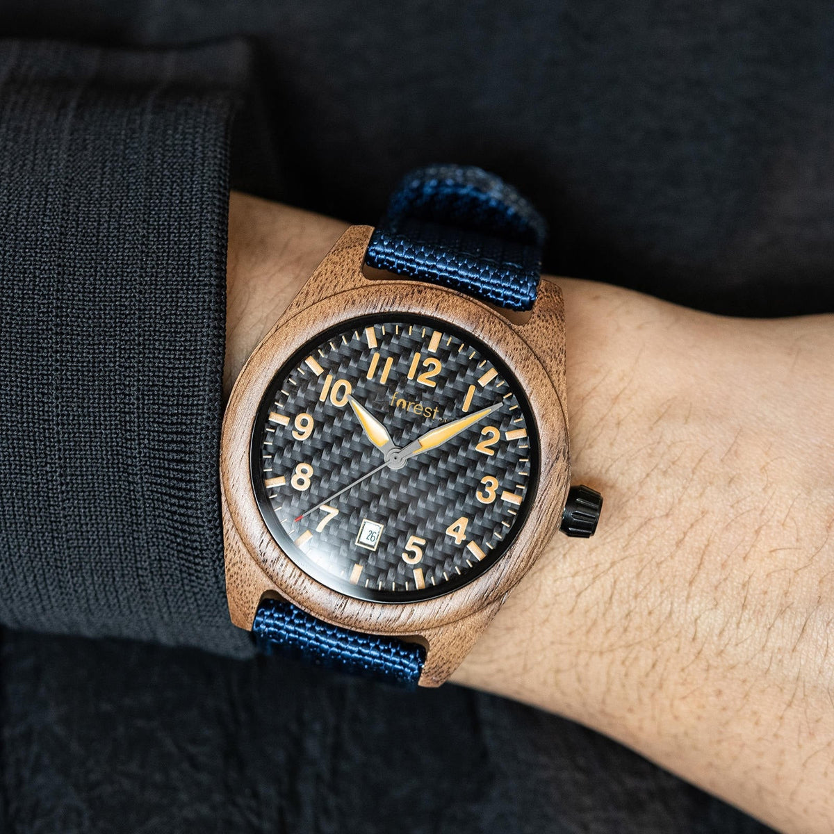 Scout wooden watch worn on the wrist below a dark sleeve