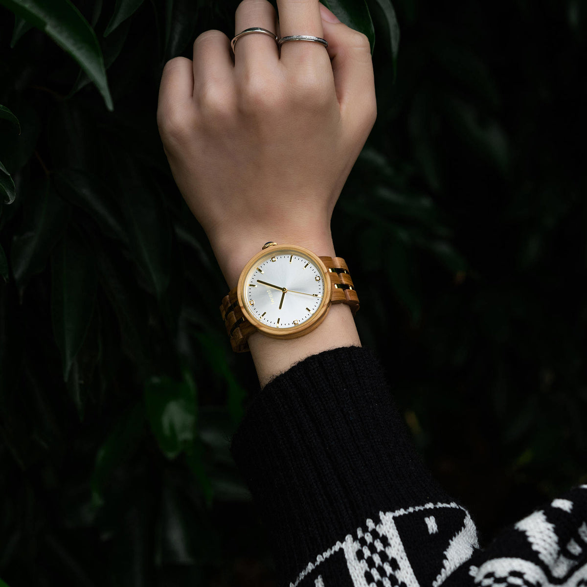 Forest wooden watch on womans wrist as she wears a jumper