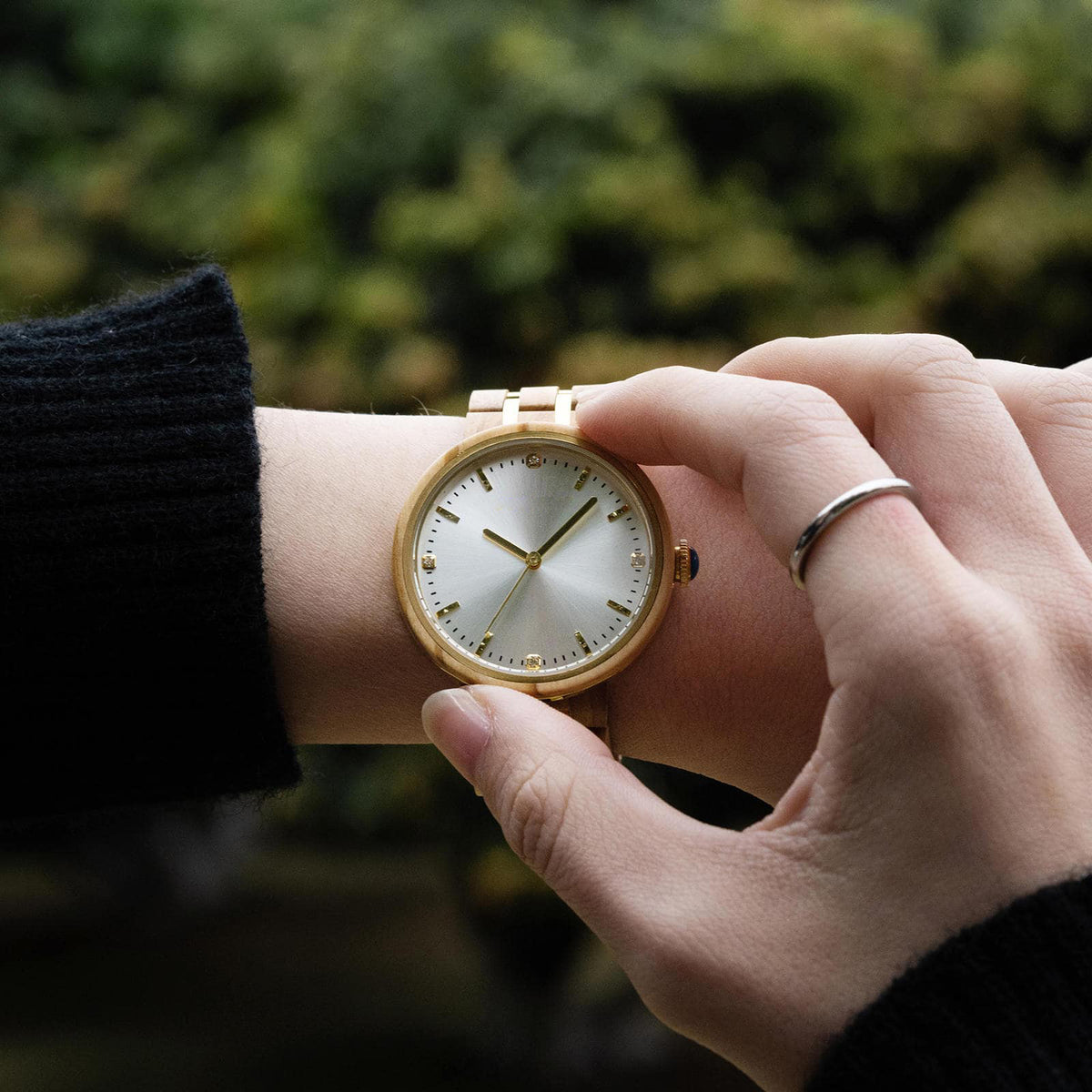 A woman setting the time on her victoria wooden watch