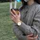 A woman drinking coffe while wearing her Forest wooden watch
