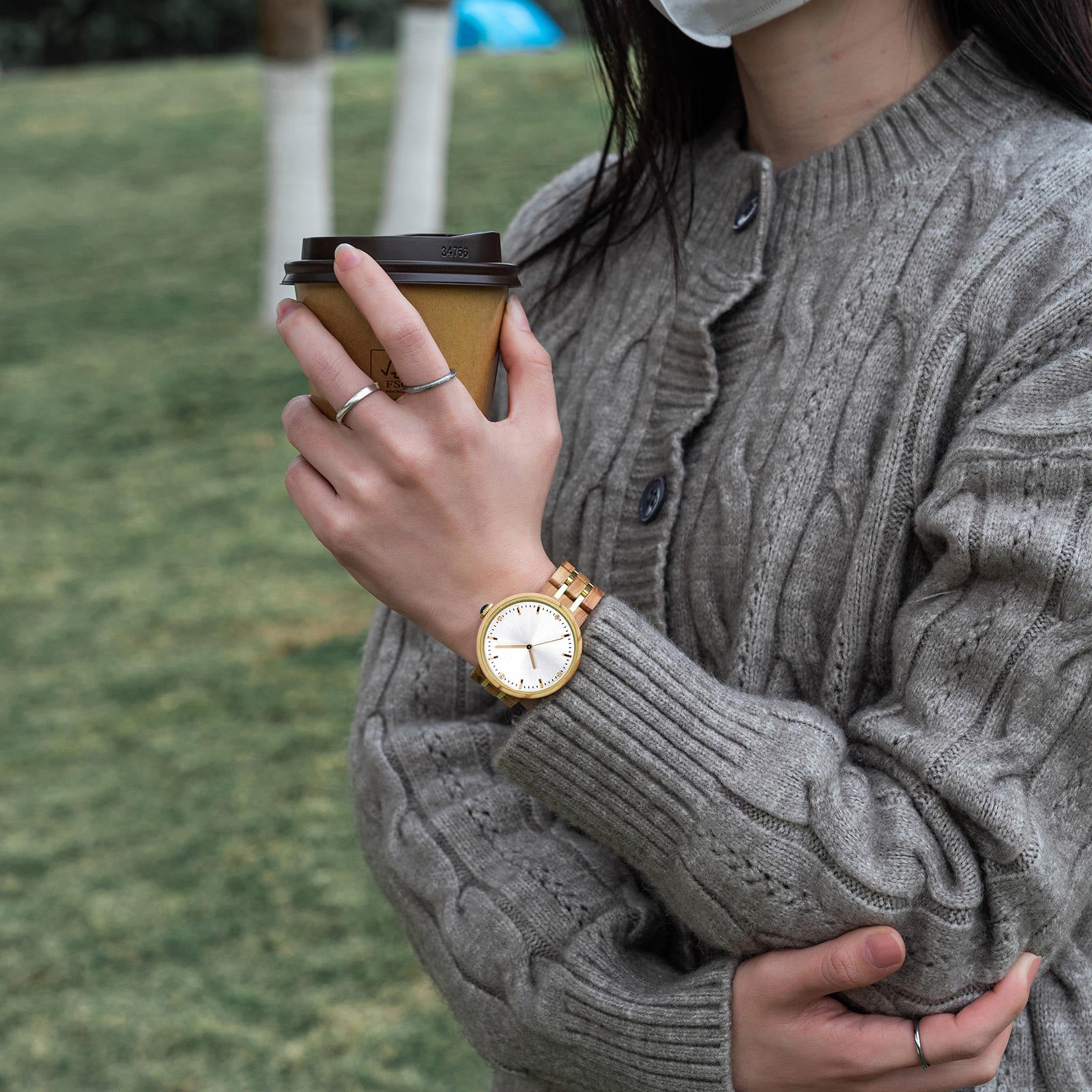 A woman drinking coffe while wearing her Forest wooden watch