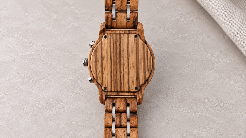Blank wooden back of the Ember watch, with four screws and its wood-and-silver bracelet, ready for engraving