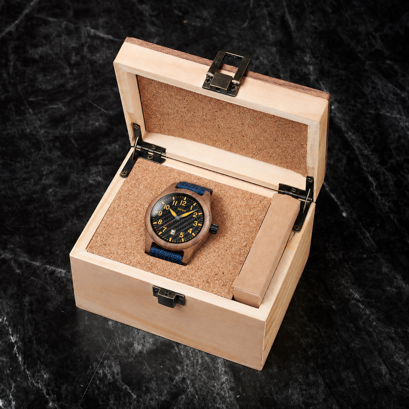 Scout wooden watch with its blue fabric strap resting in its included pale wooden gift box